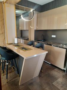 a kitchen with a counter and some chairs in it at Cataleya in Sarajevo +29 photos