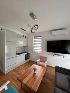 a living room with a coffee table and a kitchen at Apartmani SEEBLICK in Konjic