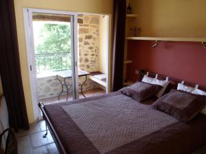 a bedroom with a bed and a sliding glass door at Les Gîtes du Lac in Montauroux