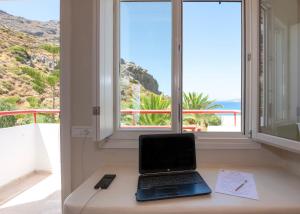 un ordinateur portable assis sur un bureau devant une fenêtre dans l'établissement Plakias Bay Hotel, à Plakias 37 autres photos