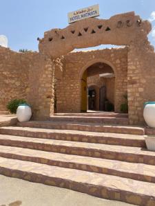 a stone building with stairs leading to a doorway at Hotel Matmata in Matmata