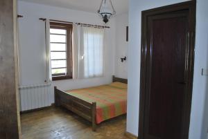Habitación pequeña con cama y ventana en Guest house "The House", en Zlatograd