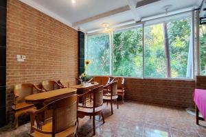 a restaurant with tables and chairs and a brick wall at OYO 94715 Homestay Kembar Syariah in Sragen