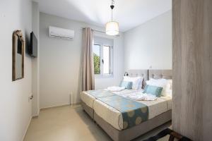 a bedroom with a bed with blue pillows and a window at Sophias View in Loutra +37 photos