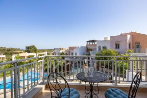 a balcony with a table and chairs and a pool at Sophias View in Loutra