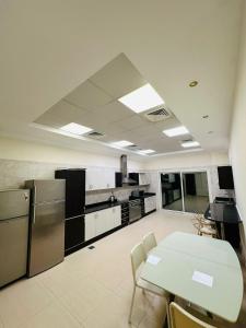 - une cuisine avec une table, une table et des chaises dans l'établissement Albarsha Villa Fully Furnished Luxury Private Master Room Ensuite Huge Space Deluxe, à Sabkhah 20 autres photos