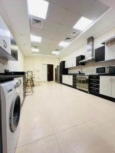 une grande cuisine avec un lave-linge. dans l'établissement Albarsha Villa Fully Furnished Luxury Private Master Room Ensuite Huge Space Deluxe, à Sabkhah