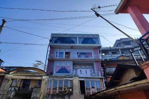 a tall building with a balcony on the side of it at OYO 94702 Putra Family Homestay Sikunir in Kejajar