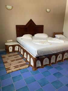 a bedroom with a large bed with a wooden frame at Hotel Matmata in Matmata