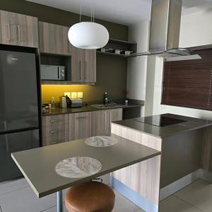 a kitchen with a table and a refrigerator at Atrium Oasis, Sandton in Johannesburg +20 photos