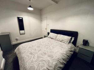 a bedroom with a large bed with a white comforter at Cosy Flat Goodmayes in Goodmayes