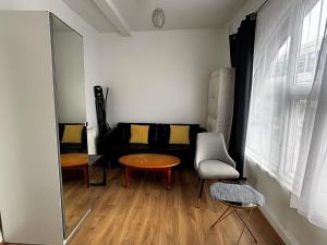 a room with a table and a chair and a mirror at Cosy Flat Goodmayes in Goodmayes +1 photo