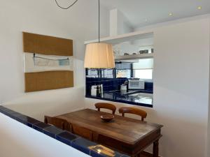 a kitchen with a wooden table and two chairs at Riera Rossello 2 by SOM menorca in Fornells +7 photos