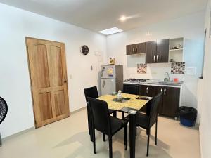 a kitchen with a table and chairs and a refrigerator at Apartamento la Isla 1-Coveñas in Coveñas