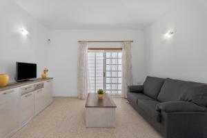 een woonkamer met een bank en een tv bij Bonita Casa Annie in Abades