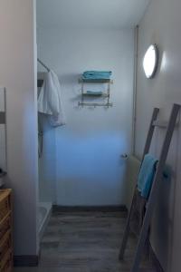 a bathroom with a white wall and a towel rack at La vallée de Gaïa in Saint-Hilaire-de-Lavit