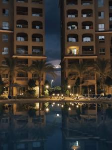 ein Hotel in der Nacht mit Pool davor in der Unterkunft Studio in Al Alamein city in El Qasaba esh Sharqīya