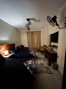 ein Hotelzimmer mit 2 Betten, einem Schreibtisch und einem Schreibtisch in der Unterkunft Studio in Al Alamein city in El Qasaba esh Sharqīya