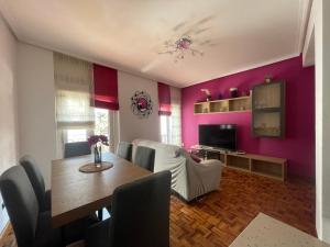 a dining room with a table and purple walls at Encantador apartamento en el centro de Castro CON PARKING in Castro-Urdiales