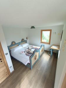 een slaapkamer met een bed en een houten vloer bij Casa Soraya 2 in Falcade