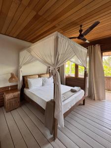 a bedroom with a bed with a canopy at Iru Maldives in Thulusdhoo +40 photos