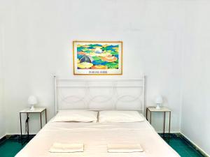 1 Schlafzimmer mit einem weißen Bett und 2 Nachttischen in der Unterkunft Villa Giordano in Acquavella