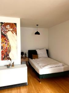 クレーフェルトにあるRooftop Flat next to HBF & Messe Düsseldorfのベッドと壁に絵が飾られた寝室