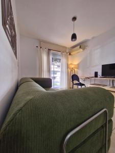 ein Schlafzimmer mit einem Bett mit einer grünen Decke in der Unterkunft Francia Apartment in Rosario