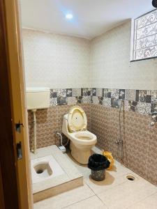a bathroom with a toilet and a sink at Tabbis Guest House in Islamabad