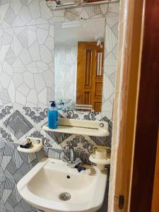 a bathroom with a sink and a mirror at Tabbis Guest House in Islamabad
