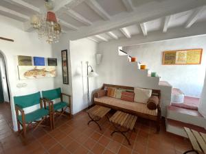 a living room with a couch and a staircase at ESGLESIA 4 by SOM Menorca in Fornells +14 photos