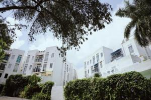 Santorini Lia Soleil at La Bella Tagaytay في Galicias: صف من مباني الشقق البيضاء مع الأشجار