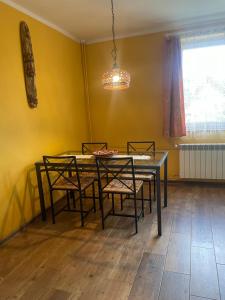une salle à manger avec une table, des chaises et un lustre dans l'établissement Apartament Ciśnianka, à Cisna 1 autre photo