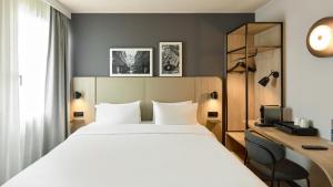 a hotel room with a bed and a desk at Campanile Prime - Argenteuil in Argenteuil