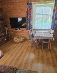 a living room with a table and a tv at Chata Javorina in Javorina +21 photos