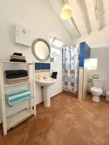a bathroom with a sink and a toilet and a mirror at La Casilla- La Almona Chica in El Chorro