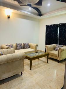 Una sala de estar con dos sofás y una mesa de café. en Quick Guest Houses, en Islamabad