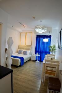 Santorini Lia Soleil at La Bella Tagaytay في Galicias: غرفة نوم بسرير وستارة زرقاء +32 صورة