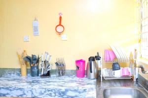 a kitchen counter with a sink and utensils at Quiet 1BR Escape in Nyeri