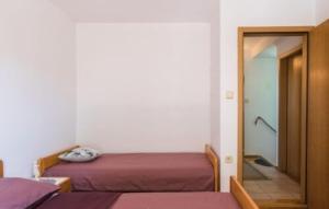 a bedroom with two beds and a door to a hallway at Villa Tina Crikvenica by Villas Guide in Crikvenica
