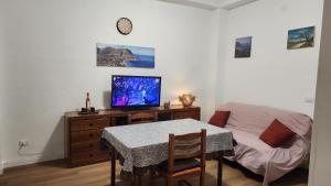 a living room with a table and a television on a dresser at La casetta di Totò in Palermo
