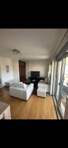 Sala de estar con 2 sofás blancos y TV en Apartment Milky, en Mostar