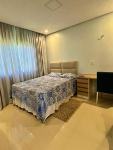 a bedroom with a bed and a desk and a window at COP30 house in gated community in Ananindeua +33 photos