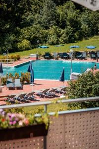 a large swimming pool with chairs and umbrellas at Vivea Hotel Bad Traunstein 