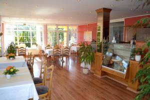 un ristorante con tavoli e sedie in una stanza di Hotel St Hubertus Wienrode a Wienrode