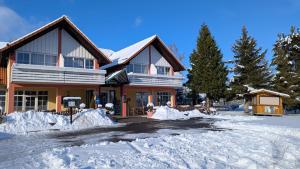 una casa con la neve davanti di Hotel St Hubertus Wienrode a Wienrode