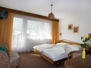 a bedroom with a bed and a large window at Hotel Alpha in Saas-Grund