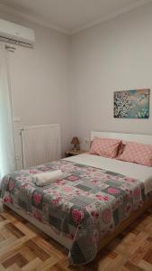 a bedroom with a bed with a quilt on it at Οδυσσέας & Σοφία in Igoumenitsa