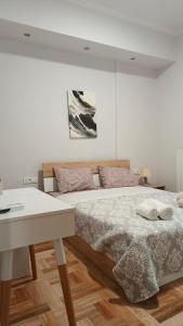 a white bedroom with a bed and a table at Οδυσσέας & Σοφία in Igoumenitsa +28 photos