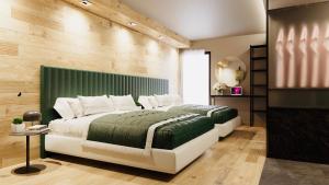 a bedroom with a large bed with a green headboard at Hotel Vienna in San Martino di Castrozza
